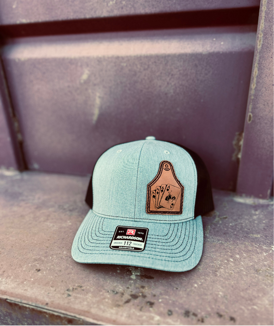 grey and black cap with a brown leather patch on a metal surface