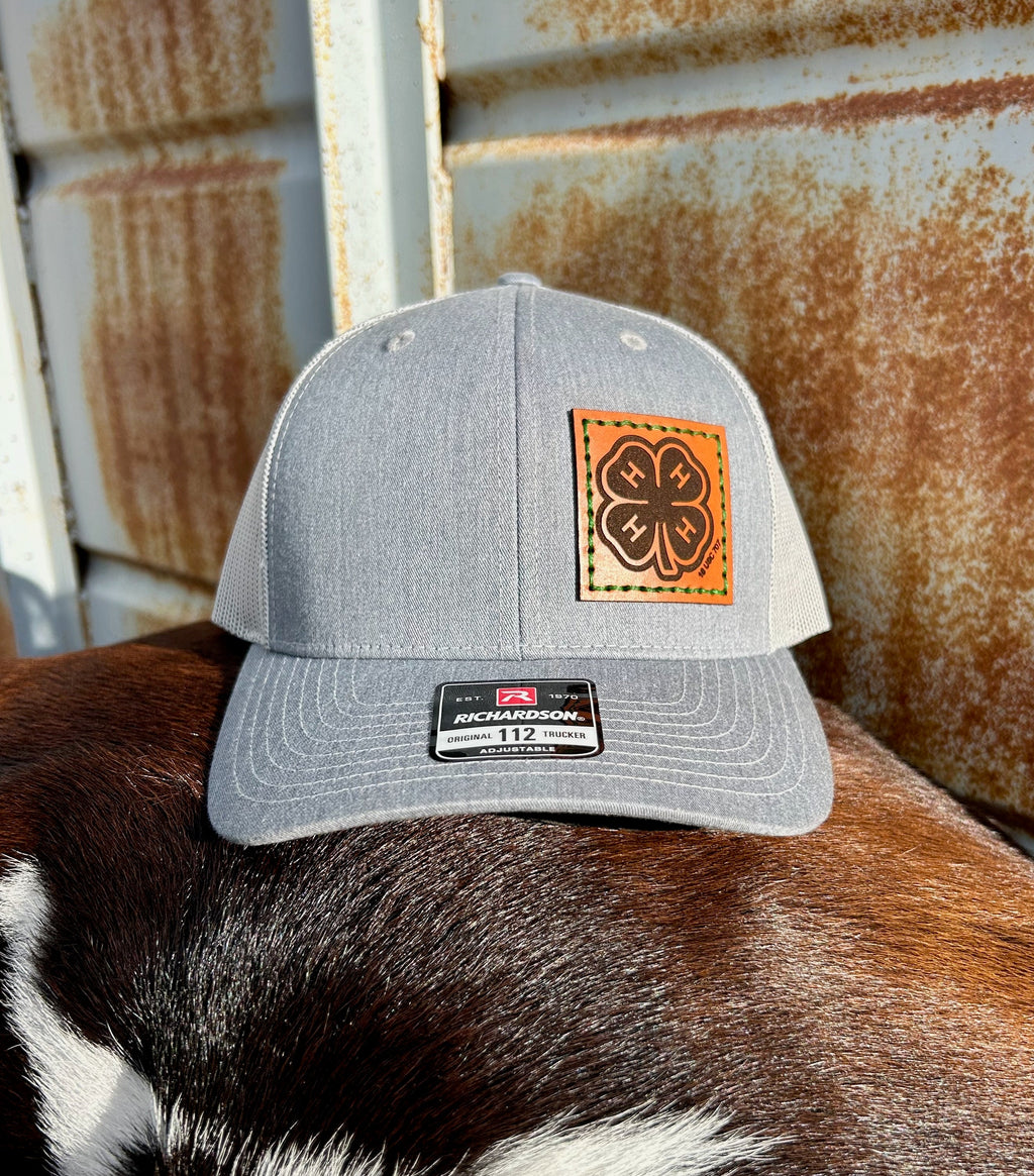 Gray cap with leather patch on a cow's back against a rusty metal background