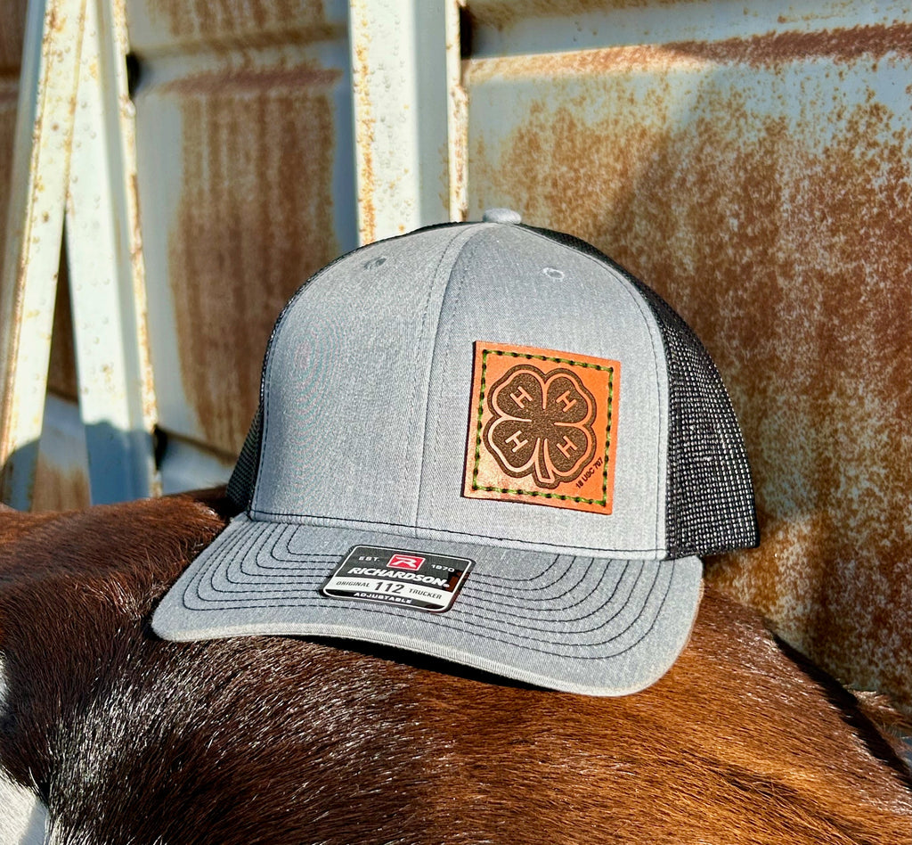 Gray trucker hat with a leather patch on a horse's back against a rusty metal background