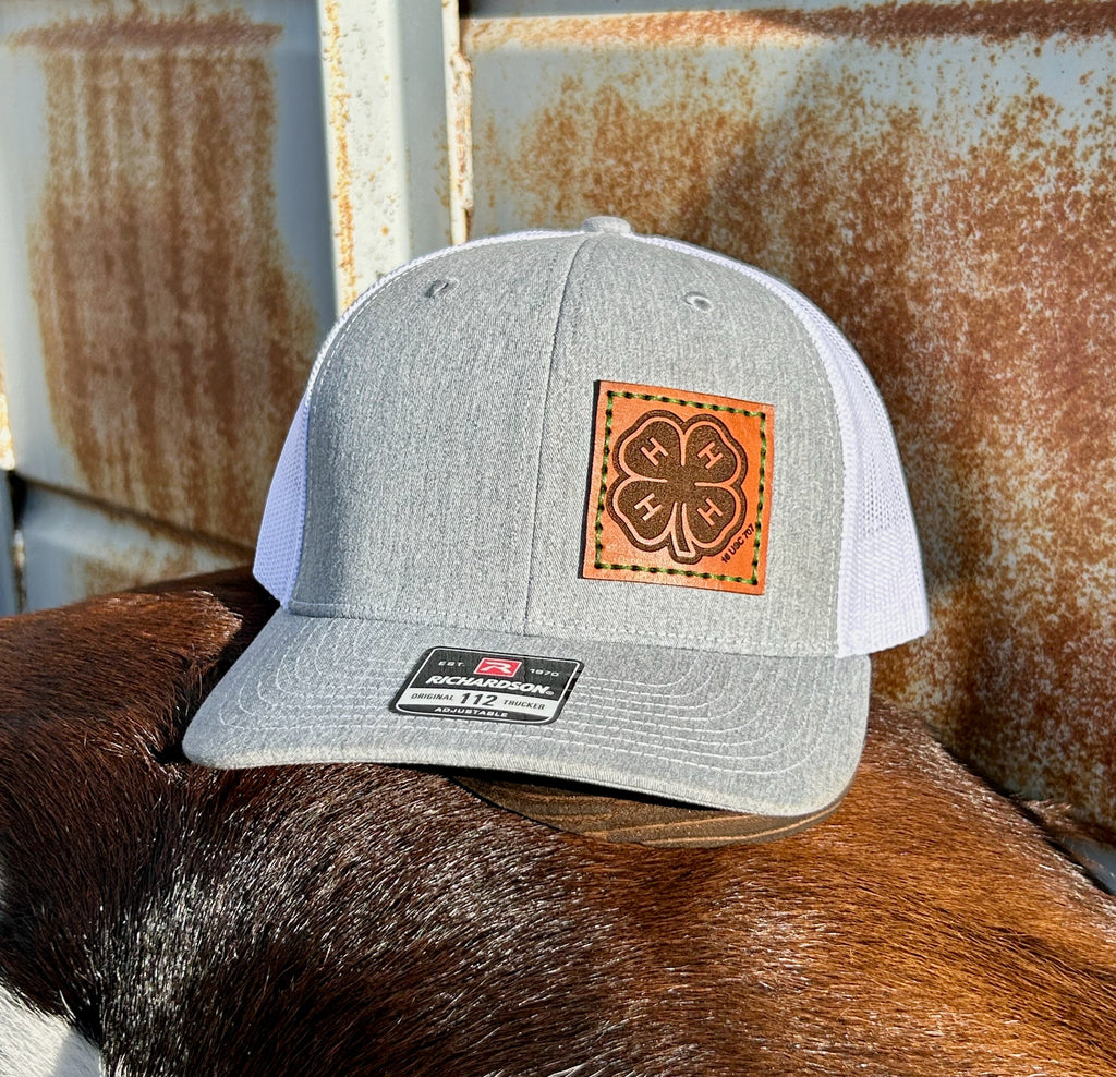 Gray cap with leather patch on a horse's back against a rusty metal background
