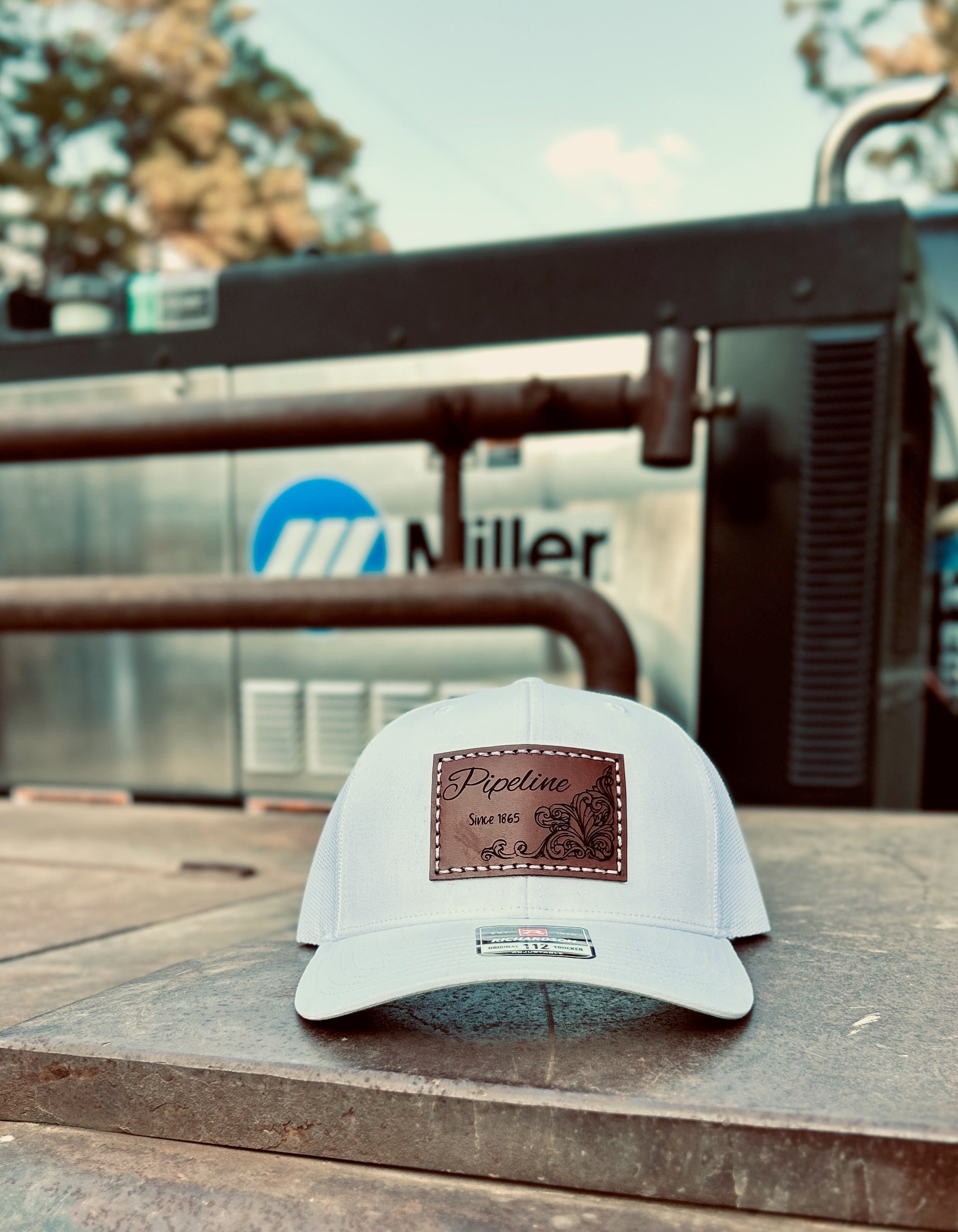 White cap with a brown logo on a metal surface with a blurred background