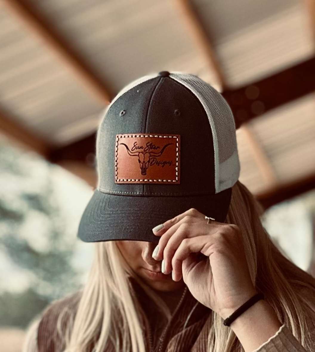 Person wearing a cap with a leather patch, blurred background