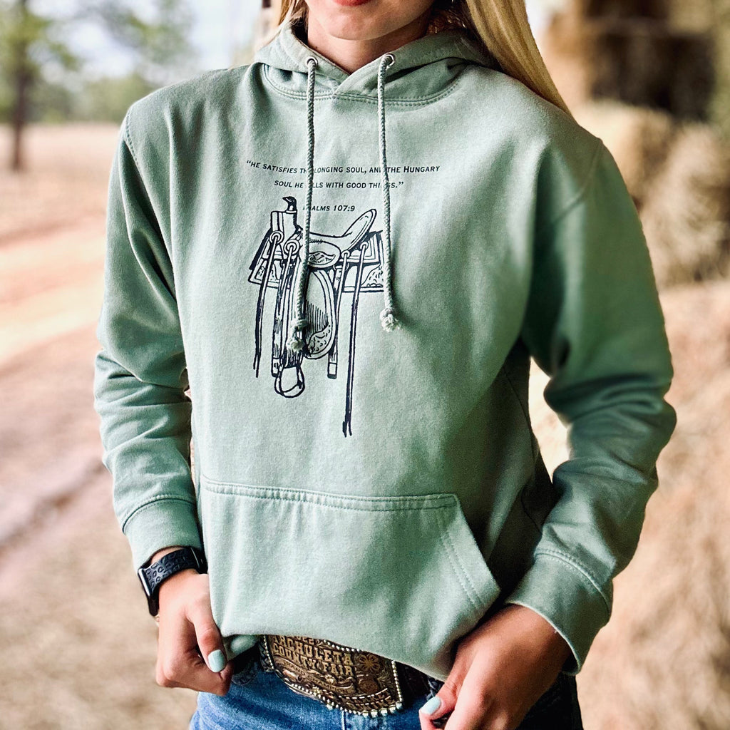 Person wearing a green hoodie with a graphic design outdoors