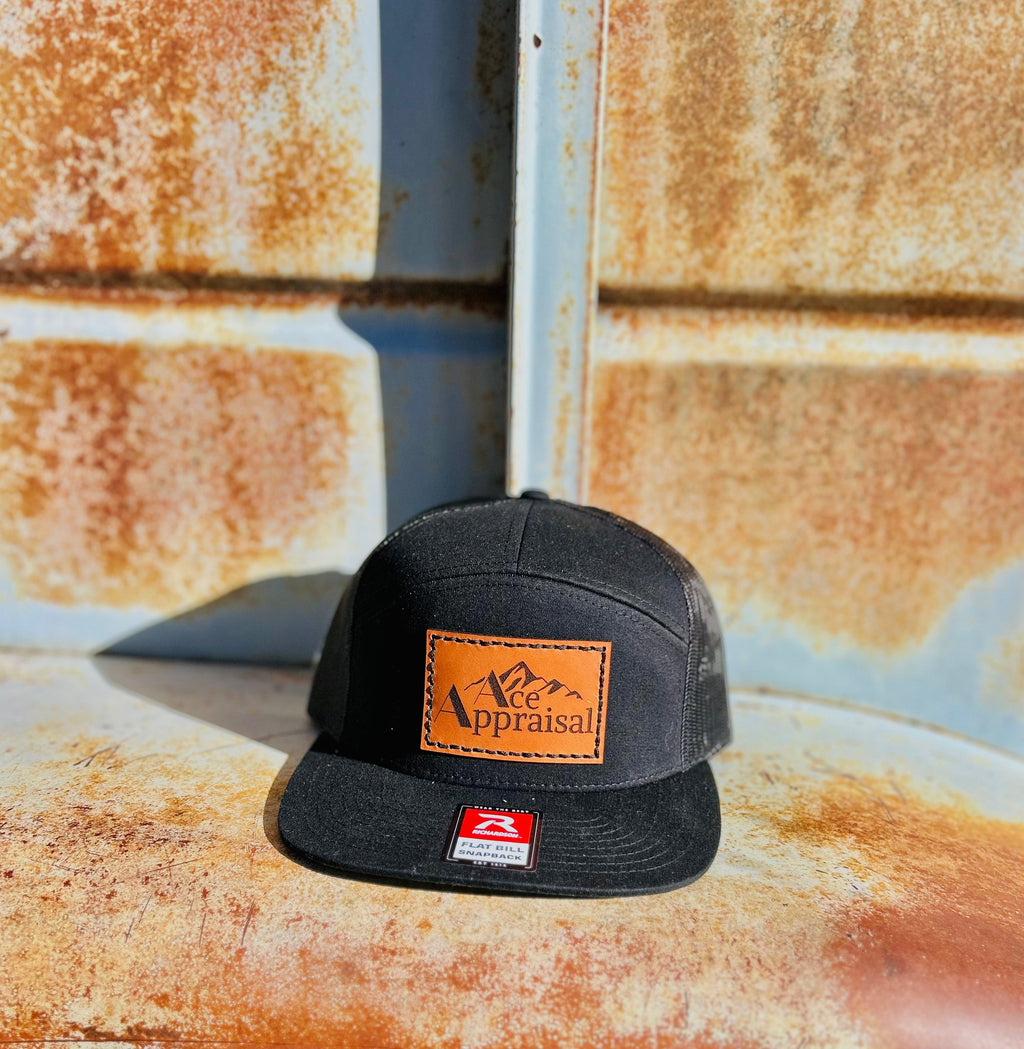 Black cap with a leather patch with a logo on a rusty metal surface