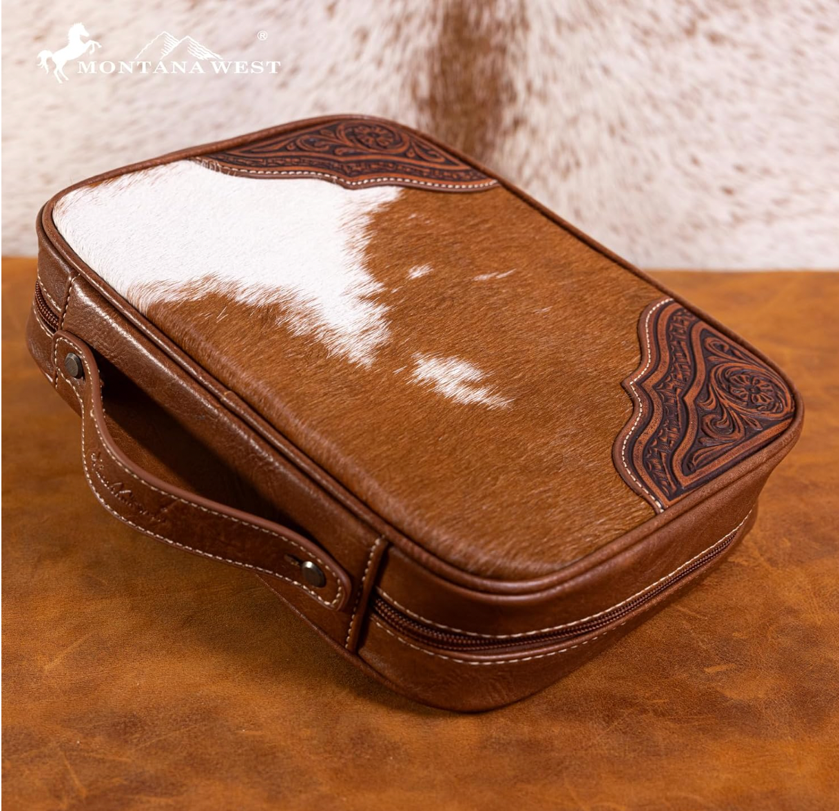 Brown leather case with cowhide pattern on a wooden surface, featuring the Montana West logo.