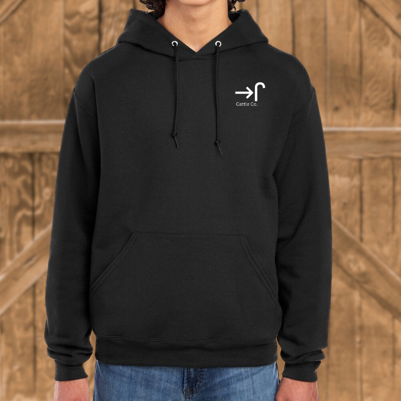 Person wearing a black hoodie with a logo on a wooden background