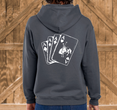 Person wearing a hoodie with a graphic of playing cards on the back against a wooden background