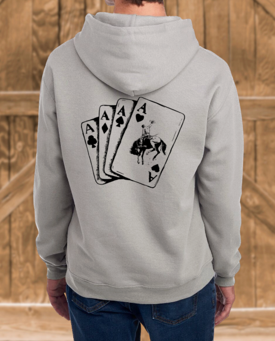 Person wearing a gray hoodie with a black graphic design on the back against a wooden background