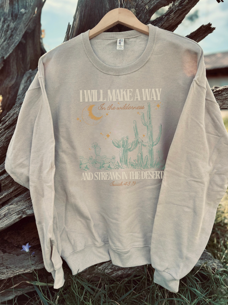 sandstone crewneck sweatshirt with a verse design on it, with an outdoor background