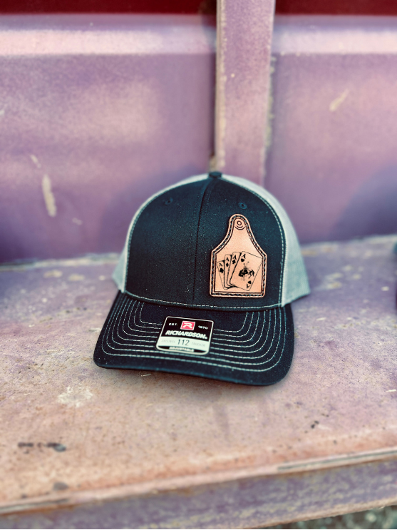 Black and grey cap with a leather patch on a rustic surface