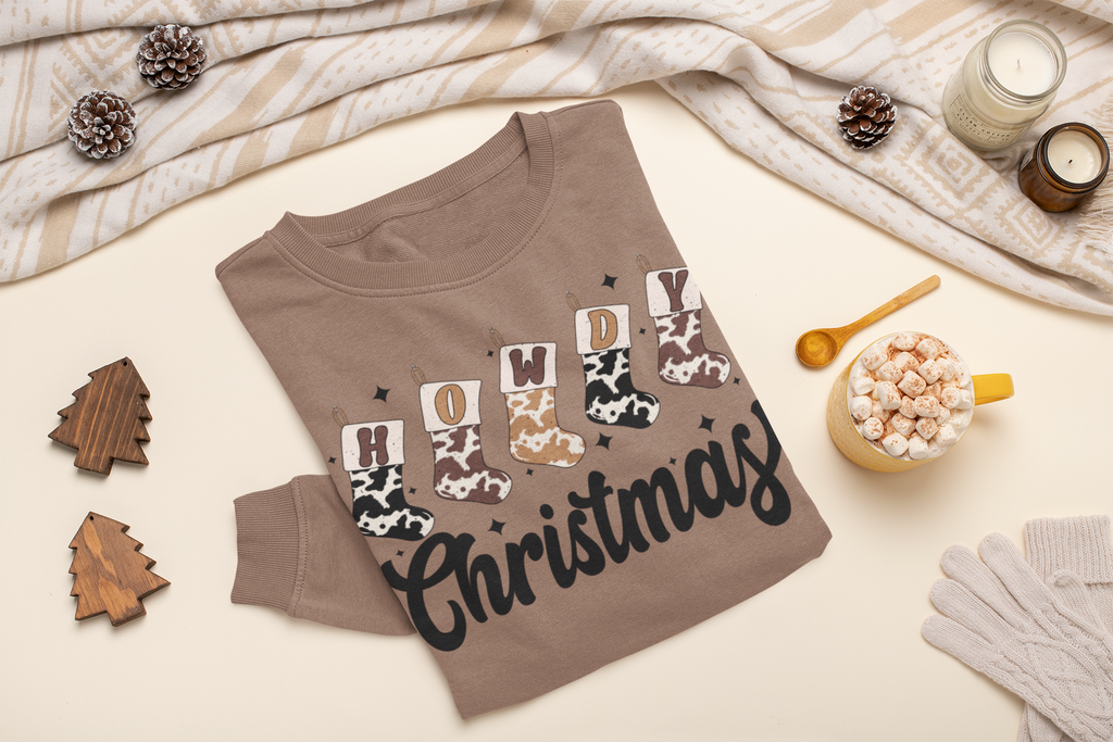 Brown sweatshirt with 'Merry Christmas' text on a festive background with pine cones, candles, and a mug.