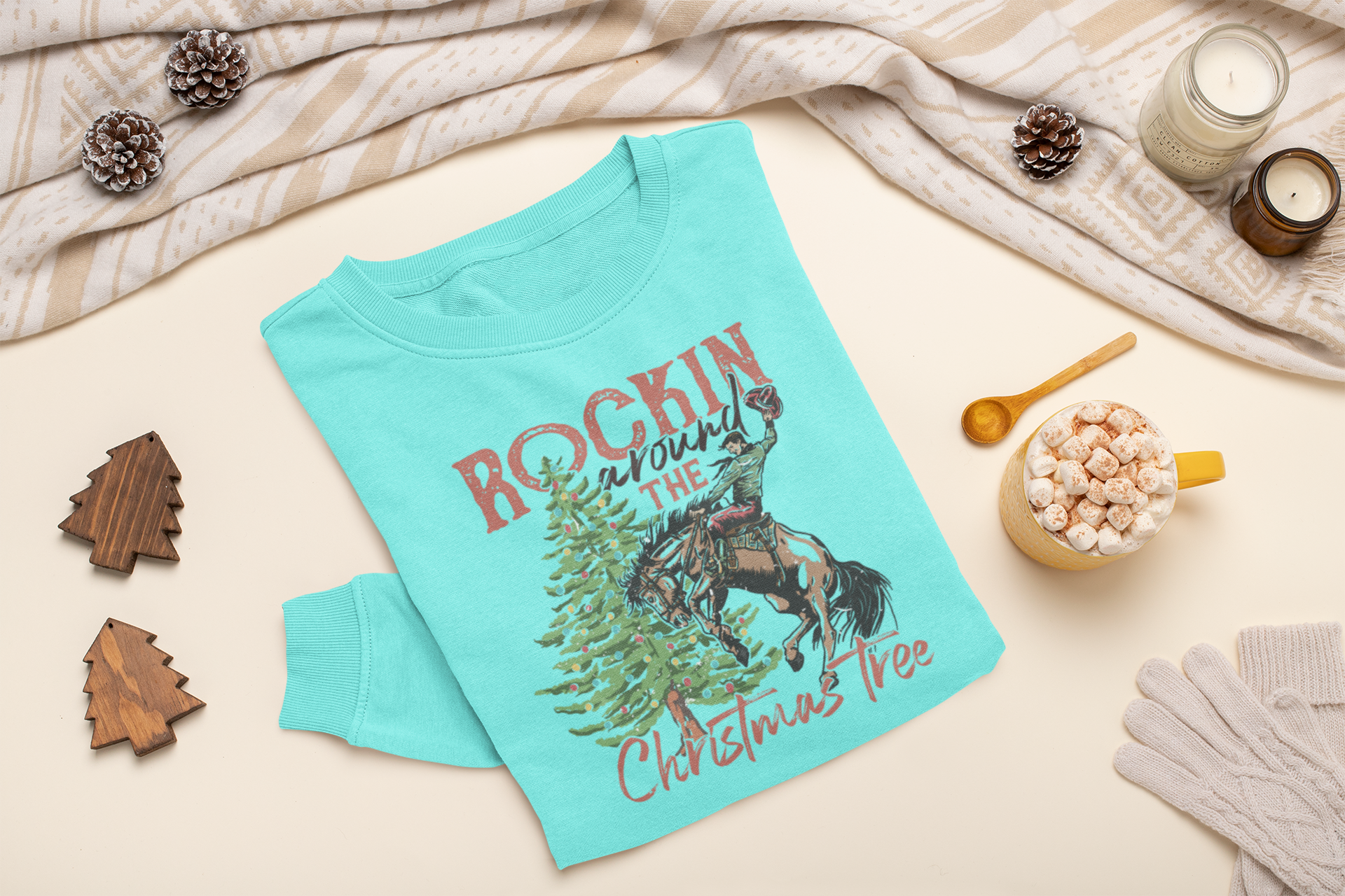 Mint sweatshirt with Christmas design on a light surface with decorative items.