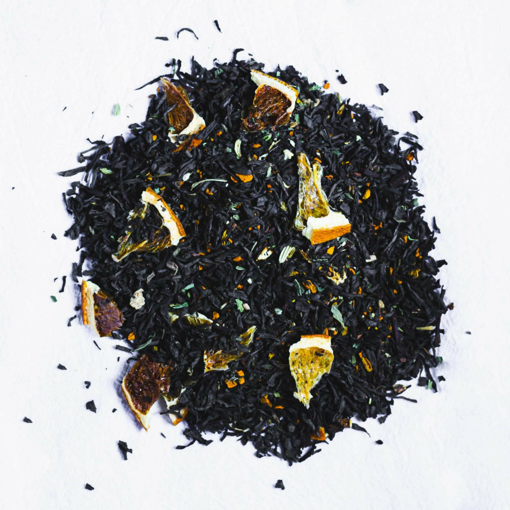 Black TNTea on white background, with dried fruit and spices